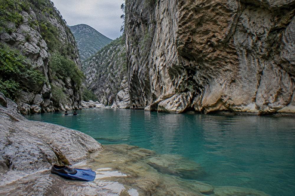 Canyon walls rising above a turquoise pool in the Sierra de Santiago