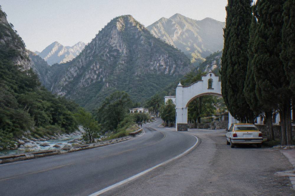Carretera Nacional curving toward the forested mountains of Santiago