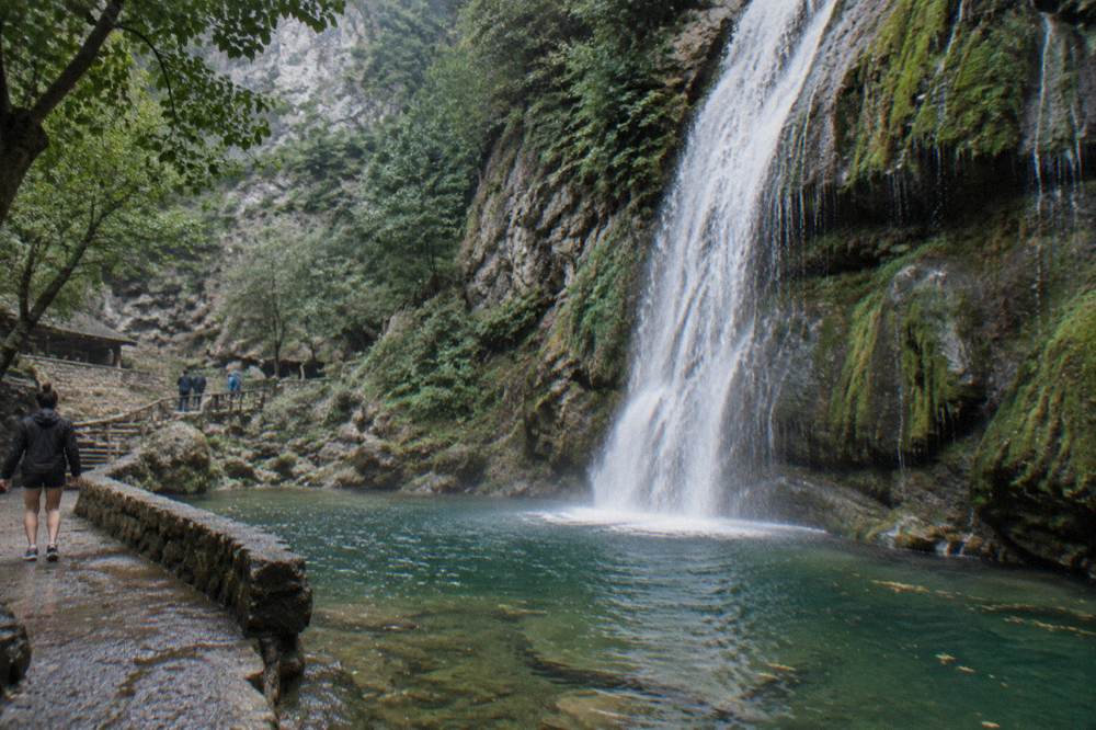 A waterfall dropping over rock into a forested gorge near Santiago