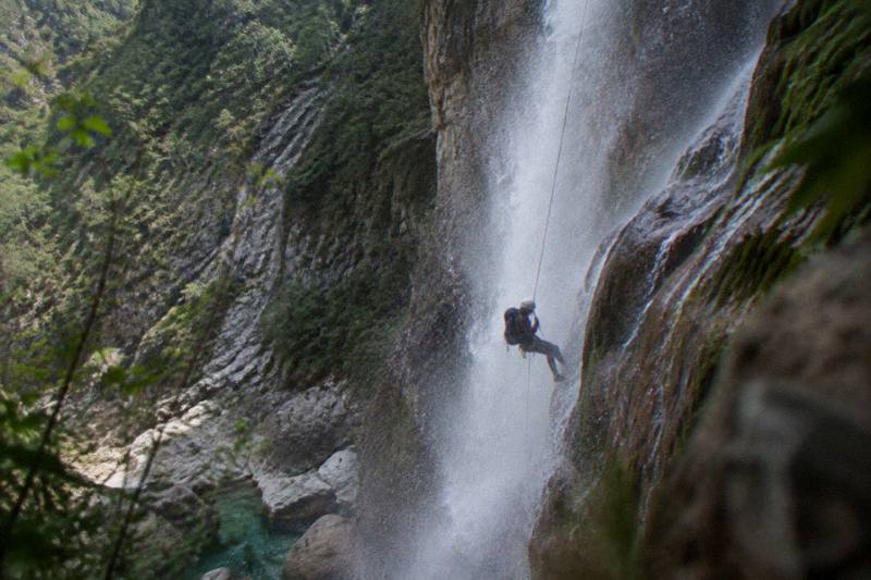 Rappeller on a limestone cliff above a waterfall near Santiago, Nuevo León