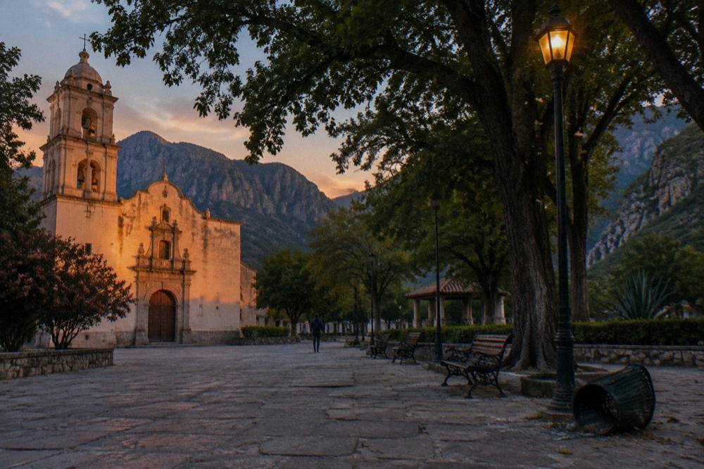 Quiet town square with shade trees and a church facade at dusk