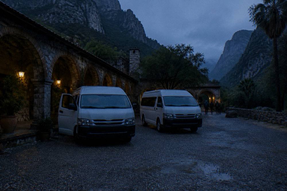 Empty parking lot under dark pre-dawn sky with vans waiting