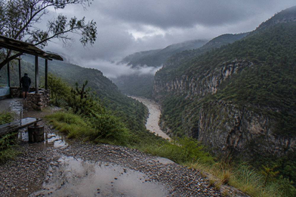 Cloudy sky over forested mountains above a river valley