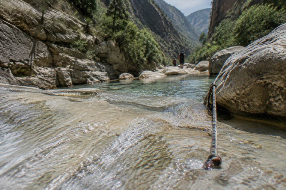 Clear water flowing over pale rock in a canyon in late spring