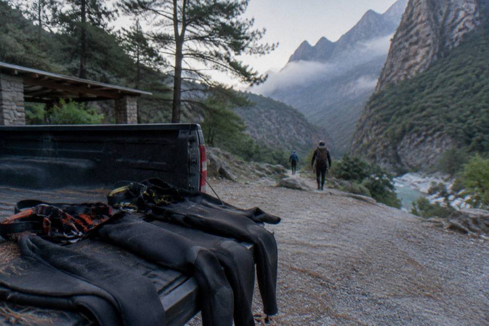 Wet suits and harnesses laid out on a truck tailgate before a canyon descent