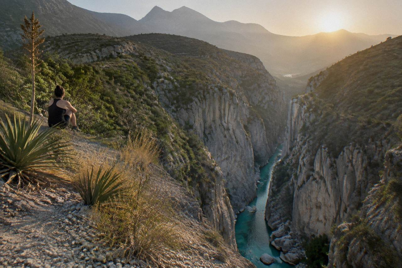 A narrow limestone canyon with turquoise water pooling between tall rock walls