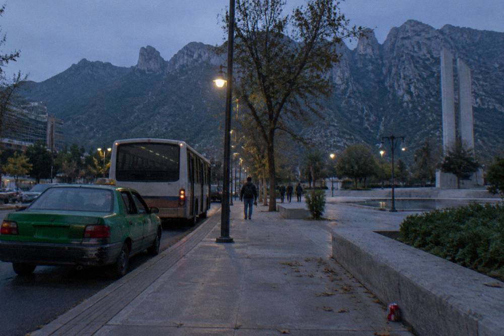 Early morning taxis and buses on a quiet Monterrey avenue before dawn