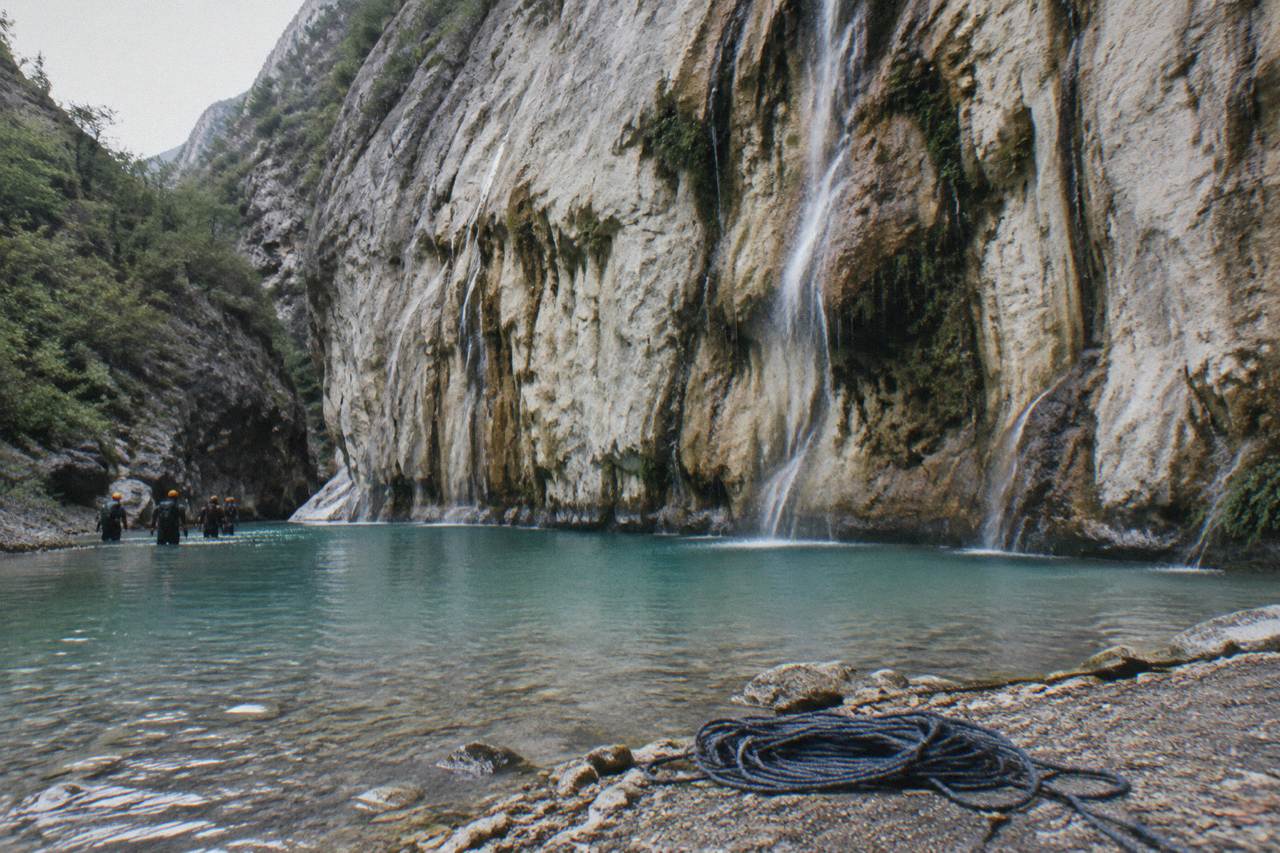 Steep forested canyon walls above a turquoise pool in the Sierra de Santiago near Monterrey